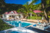 Luxury St Barts villa with red-roofed pavilions, private pool, jacuzzi, and tropical gardens near the beach.