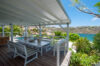 Covered outdoor dining area with ocean view at luxury villa st barths surrounded by lush tropical gardens