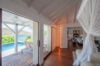 Bright bedroom opening to pool terrace with ocean view at st barth villa rental designed for relaxation.