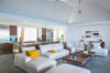 Spacious open-plan living room at st barths villas with modern design, white sofas, and view toward tropical garden.