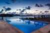 Infinity pool overlooking the ocean at sunset at a luxury St Barts villa rental.