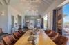Dining area in luxury st barts villa with high vaulted ceiling and terrace view of the hills.