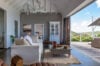 Elegant living room in luxury st barts villa opening onto terrace with hillside and ocean views.