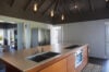 Modern kitchen with wooden island and pendant lighting, private villa rental in St Barts