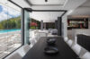 Modern dining area with glass walls opening to pool terrace at private villa rental in St Barths.