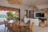 Open-plan living and dining area with sea view and natural wood accents at luxury villa rental in St Barths