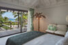 Elegant bedroom with sea-view balcony and tropical accents at a luxury St Barths villa rental