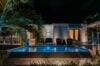 Villa Armancaya illuminated at night with glowing pool and tropical palms, a serene luxury villa in St Barts.