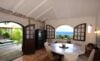 Bright dining room with arched windows and ocean view opening to the pool at a St Barts villa rental