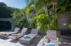 Sun terrace with lounge chairs and tropical greenery at a St Barths luxury villa rental.