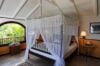 Airy bedroom with canopy bed and tropical garden view at a private St Barts villa rental