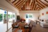 Open-plan living and dining area with vaulted wood ceiling and terrace view at Villa Plumbago, st barts villa rental