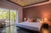Contemporary bedroom with king bed, warm lighting, and terrace access at a luxury villa rental in St Barts