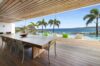 Open-air dining terrace with wooden ceiling and infinity pool overlooking the ocean at a St Barths luxury villa rental.