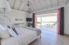 Airy bedroom with sea view terrace, vaulted ceiling, and soft tones at a luxury villa rental in St Barts