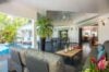 Spacious open-plan living area with tropical plants, poolside lounge, and dining space at a luxury villa in St Barts