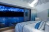 Serene bedroom of st barts villa with ocean view at dusk, featuring blue and white coastal decor and soft lighting