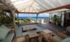 Shaded outdoor lounge with sea views and teak furniture at a luxury St Barths villa rental