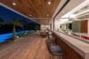 Evening view of open-air kitchen and terrace bar overlooking illuminated pool at luxury villa rental in St Barthélemy.