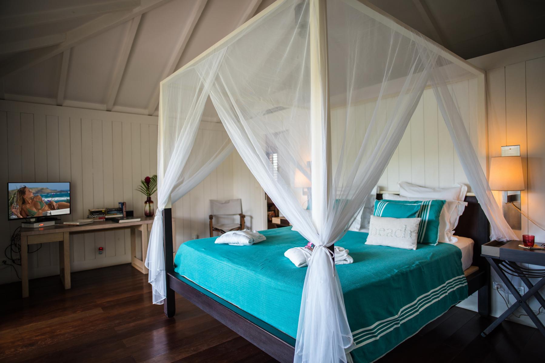 Bedroom with four-poster bed and turquoise linens at Villa Plumbago, st barts villa rental