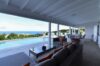 Covered terrace with outdoor seating and dining area overlooking infinity pool and ocean at a luxury villa in St Barts