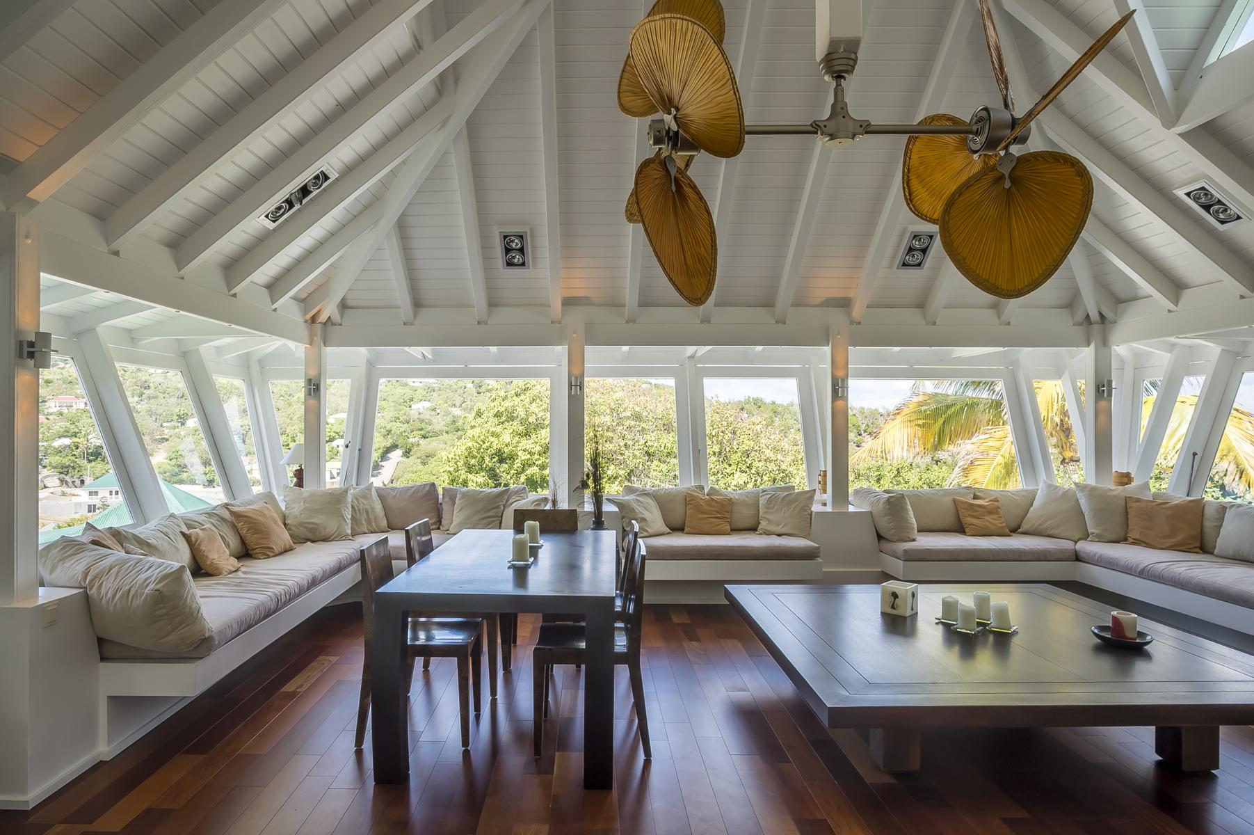 Luxury villas St Barts with bright open living room featuring high white ceilings, wooden floors, and panoramic island views.