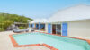 Sunlit courtyard with private pool and blue-shuttered suites at vacation rental st barth