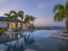 Evening view of illuminated infinity pool and palm-fringed terrace at luxury villa rental in St Barths.