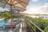 Sunset view over Caribbean Sea from pool terrace with loungers and umbrellas at luxury villa rental in St Barths