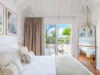 Bright bedroom with terrace access and soft neutral decor at a luxury St Barths villa rental.