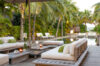 Elegant outdoor lounge with cushioned sofas, palm trees, and poolside ambiance at a private St Barts villa rental