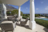 Ocean-view terrace of a St Barts villa with cushioned lounge chairs, shaded columns, and serene views of the Caribbean horizon.