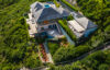 Aerial view of hillside luxury villa with terraces, pool, and lush greenery in St Barths